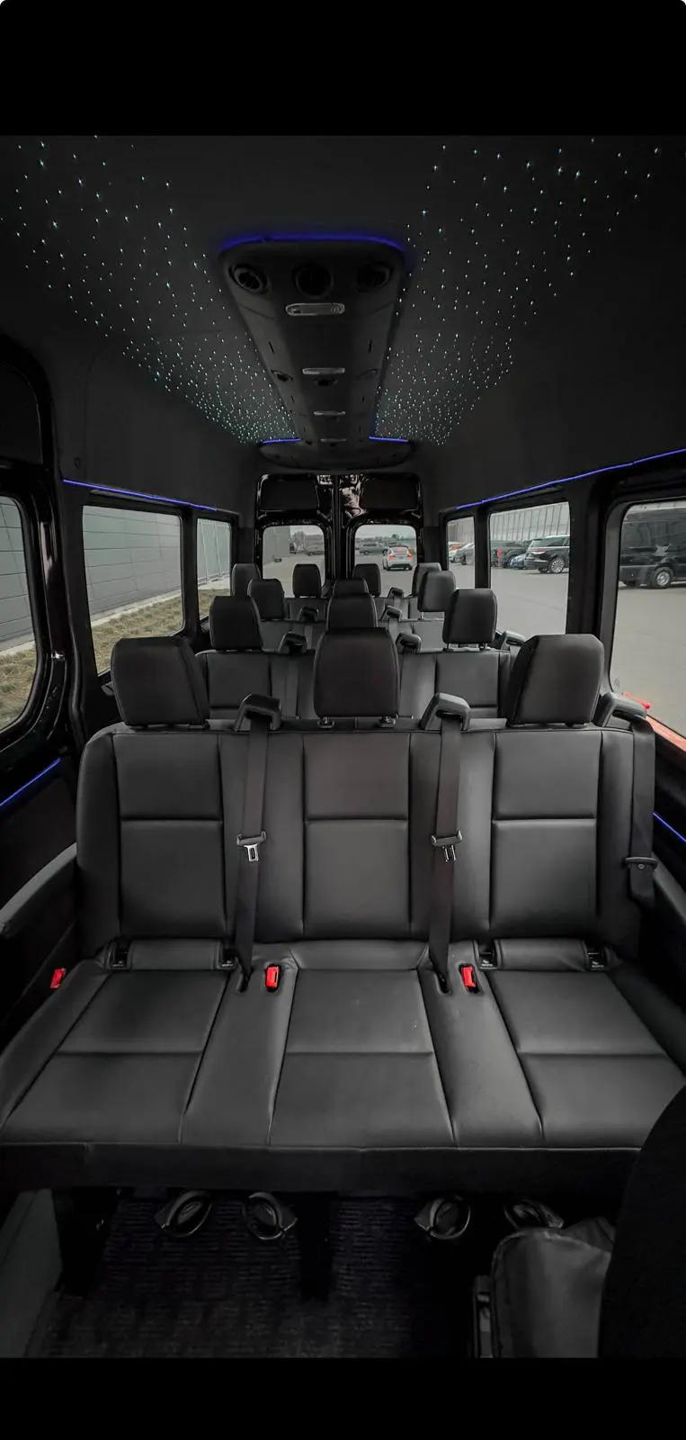 Large group Sprinter interior with black seating and starlight ceiling